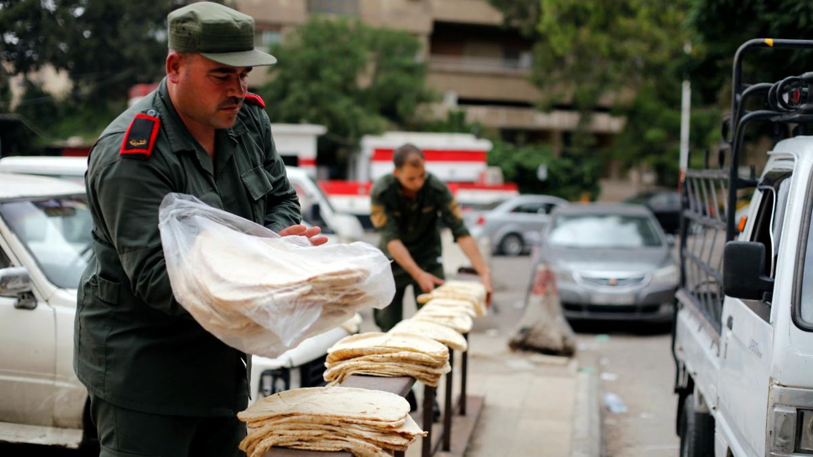 Un policia sirià reparteix l'ajuda humanitària que arriba a Damasc