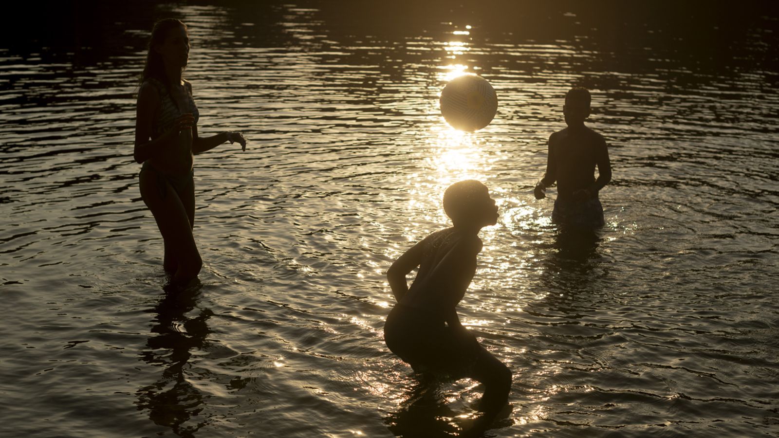 Un grup de persones es refresca en un riu durant l'onada de calor
