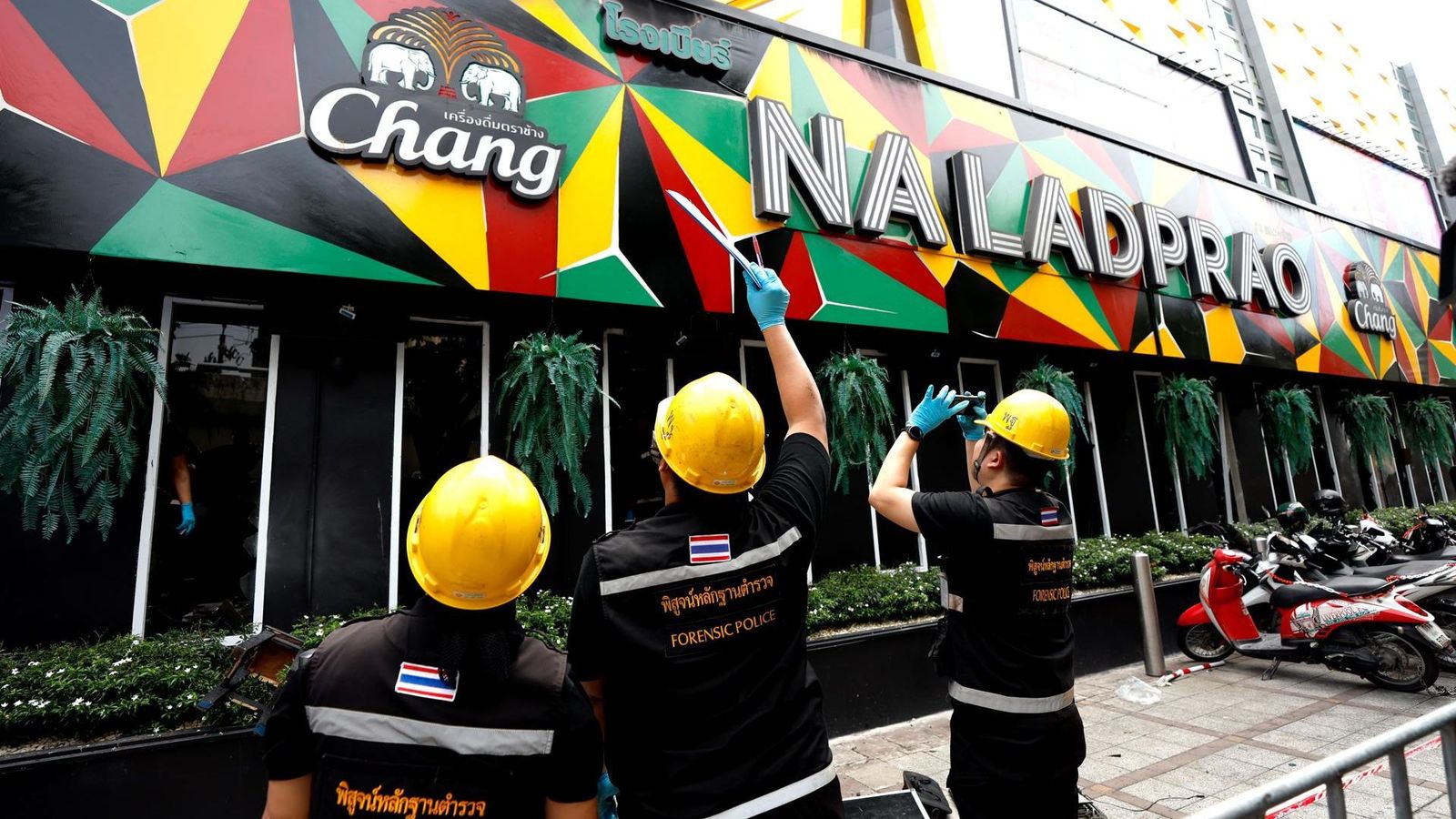 Tres agents de policia observen la façana de la cervesseria de Bangkok on s'ha registrat el letal incendi