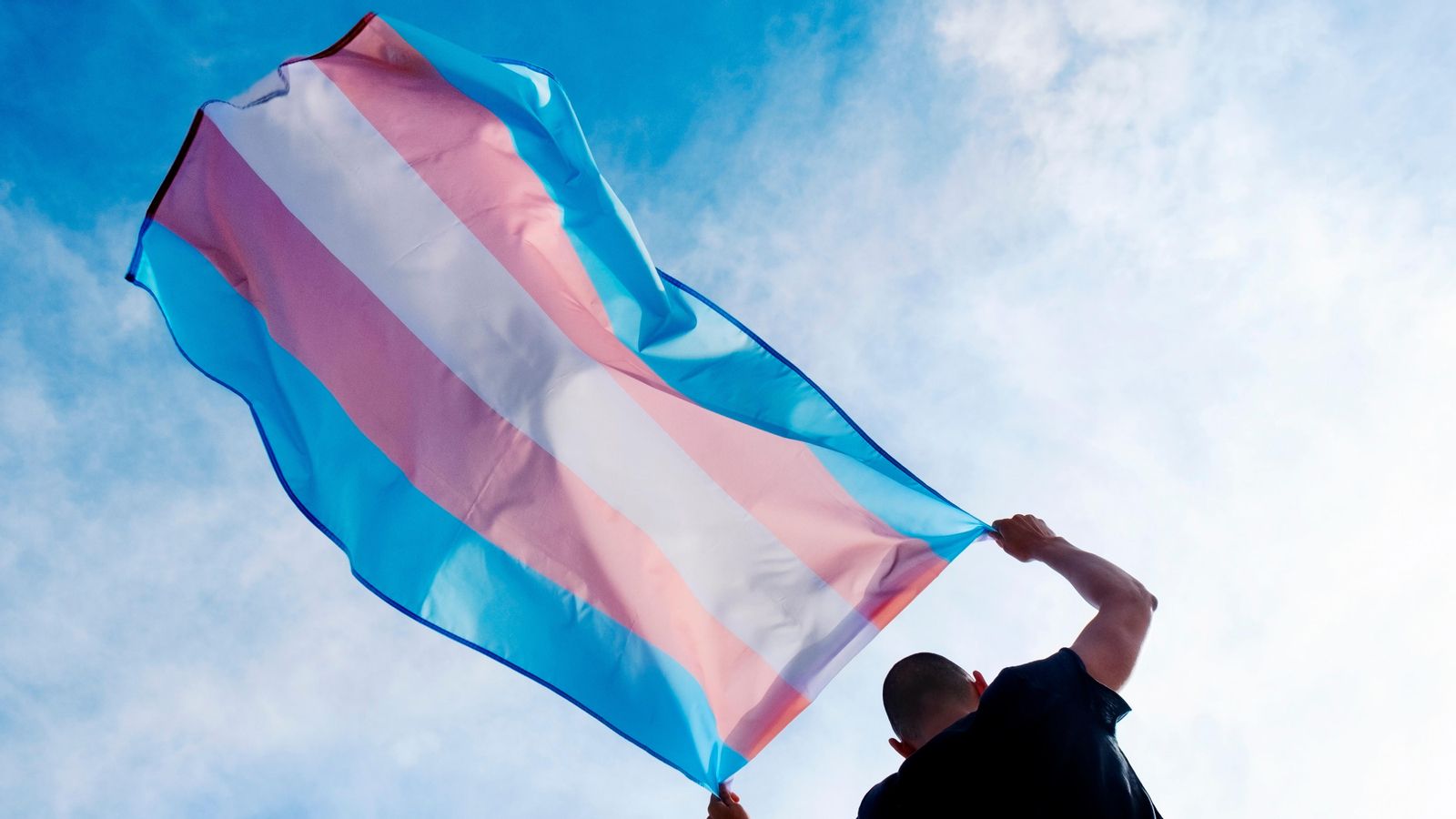 Una persona amb una bandera trans