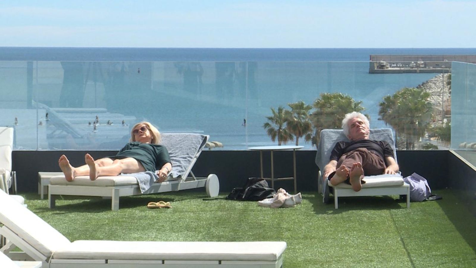 Dos turistes prenen el sol en la terrassa d'un hotel