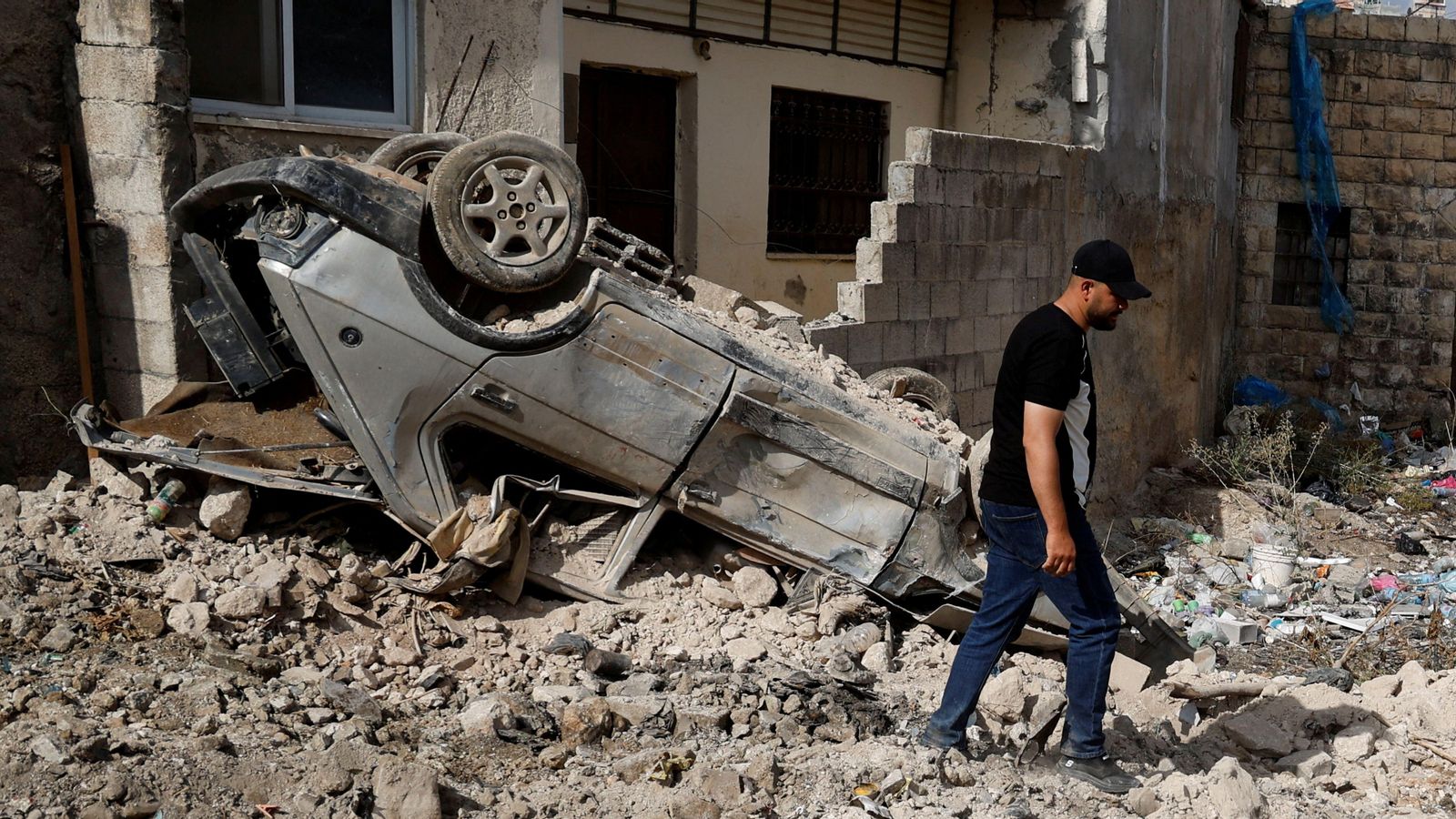 Un palestí camina al costat d'un vehicle destrossat després d'un bombardeig israelià a Tubas, en la Cisjordània ocupada
