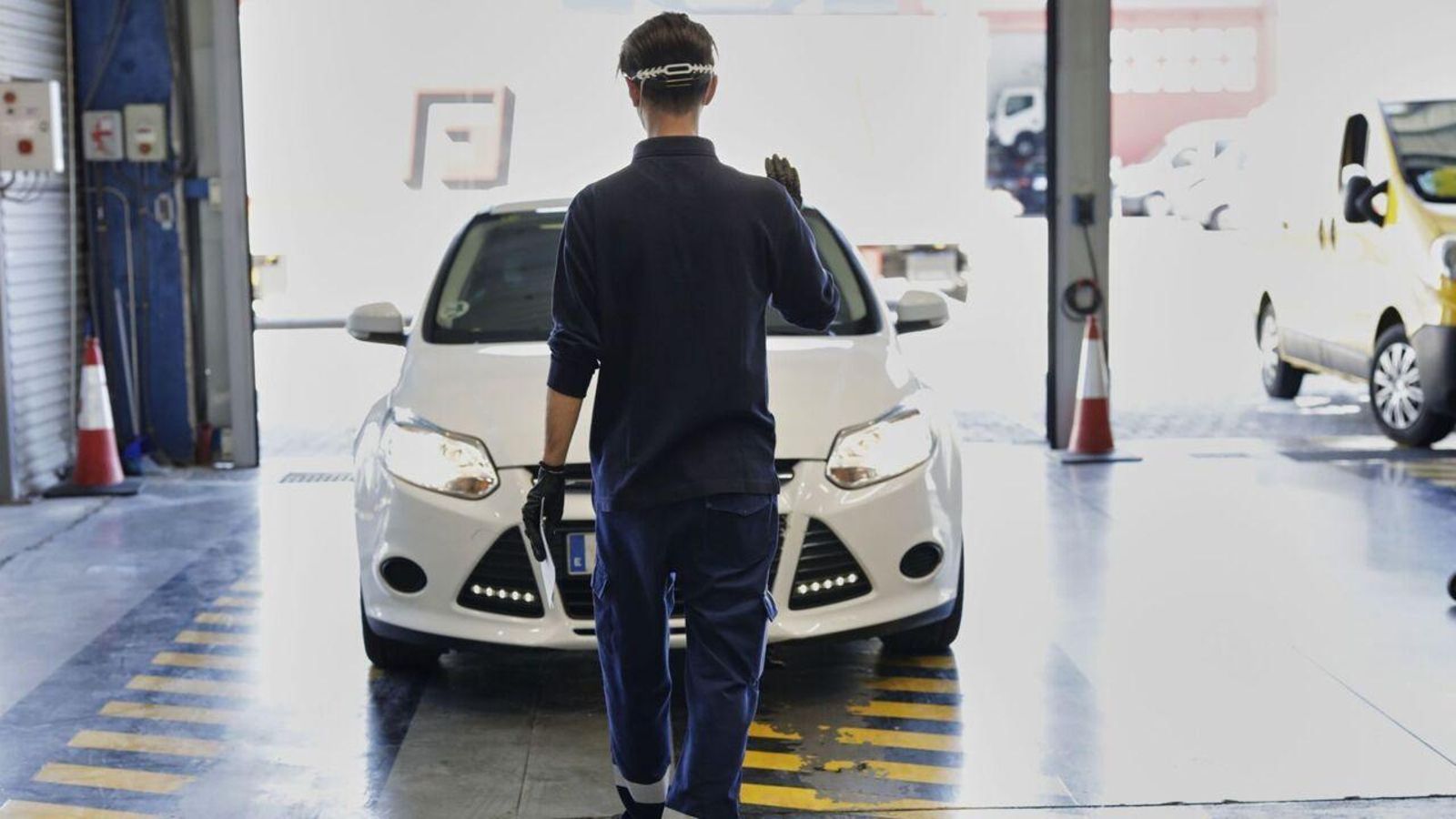 Un treballador d'una estació de la ITV dona instruccions a un conductor, en una imatge d'arxiu