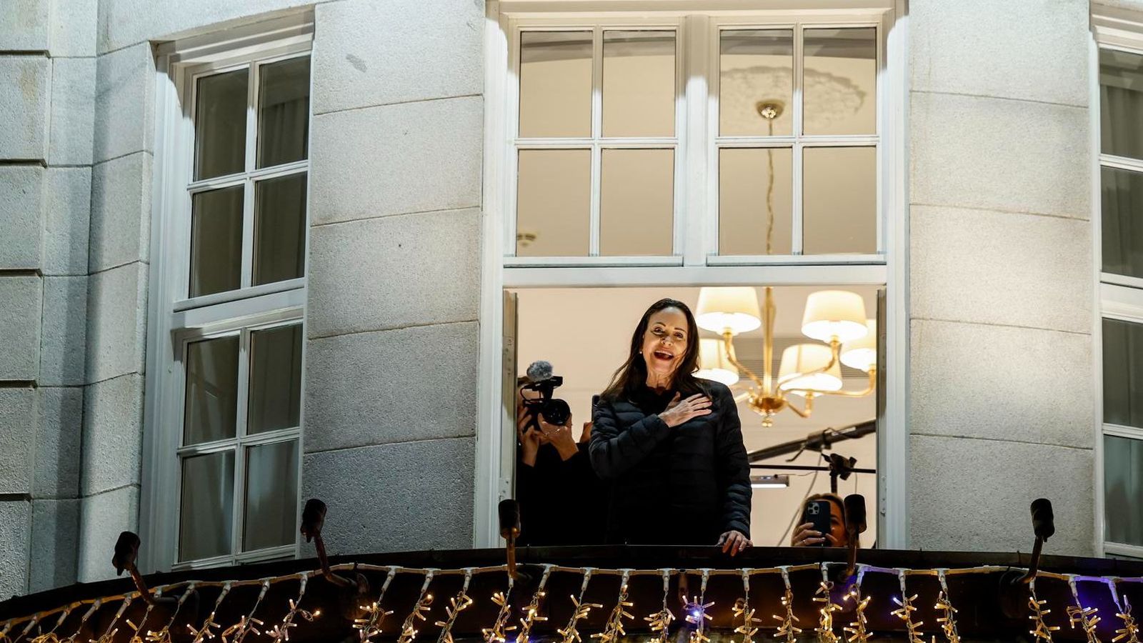 María Corina Machado, amb la mà al cor, saluda els seguidors des del balcó de l'hotel on s'allotja a Oslo