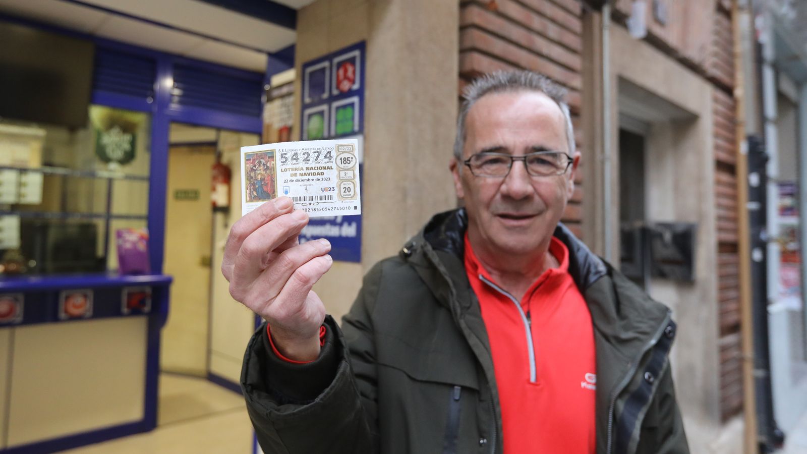 Un dels agraciats mostra el seu dècim amb un dels cinquens premis del Sorteig Extraordinari de Loteria de Nadal 2023