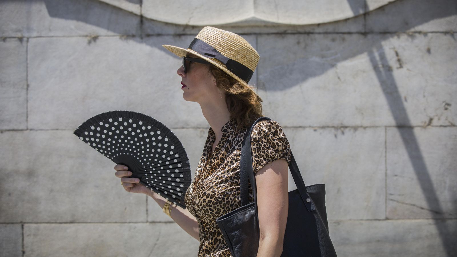 Una dona lluita contra la calor amb un ventall Una dona lluita contra la calor amb un ventall