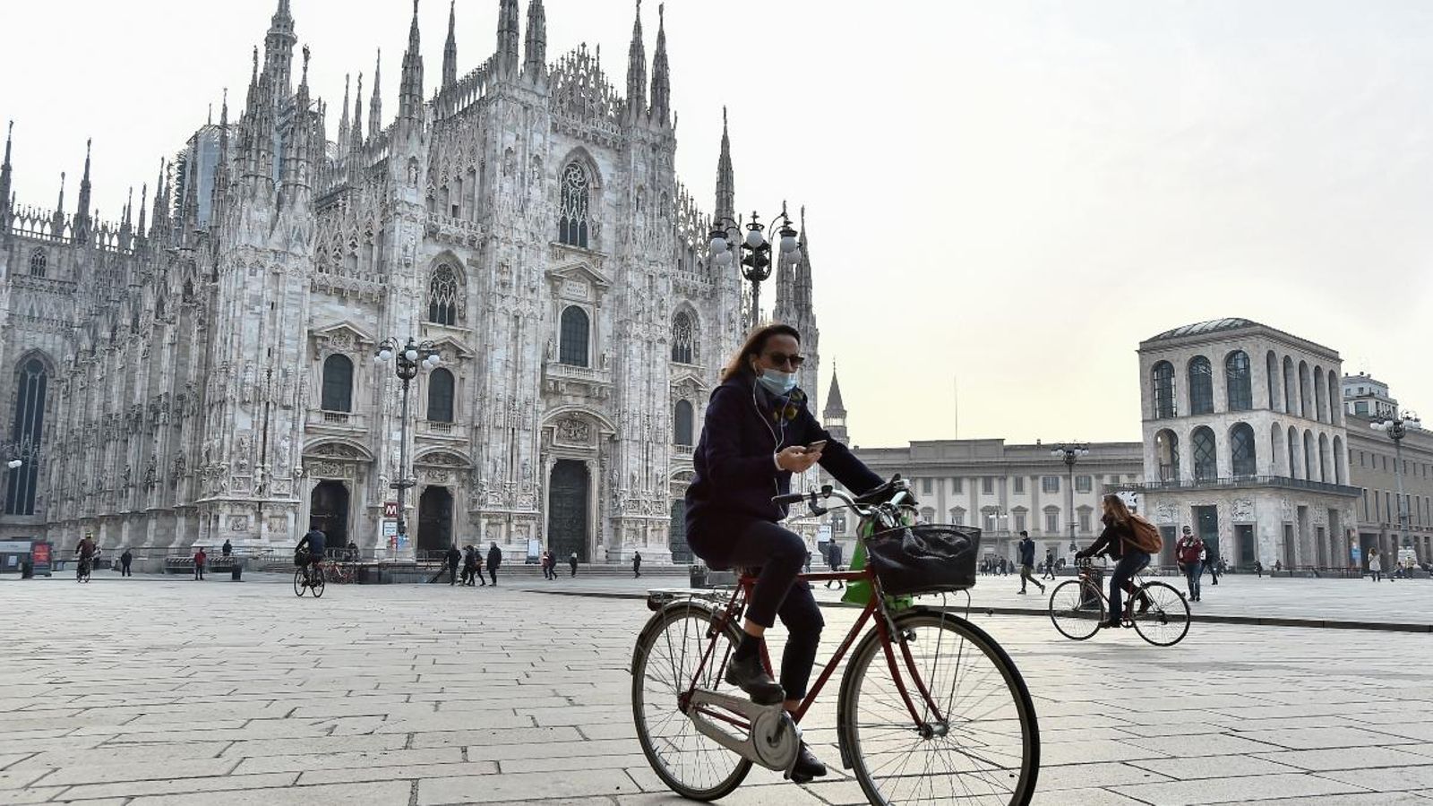Una dona en bicicleta a la plaça del Duomo de Milà