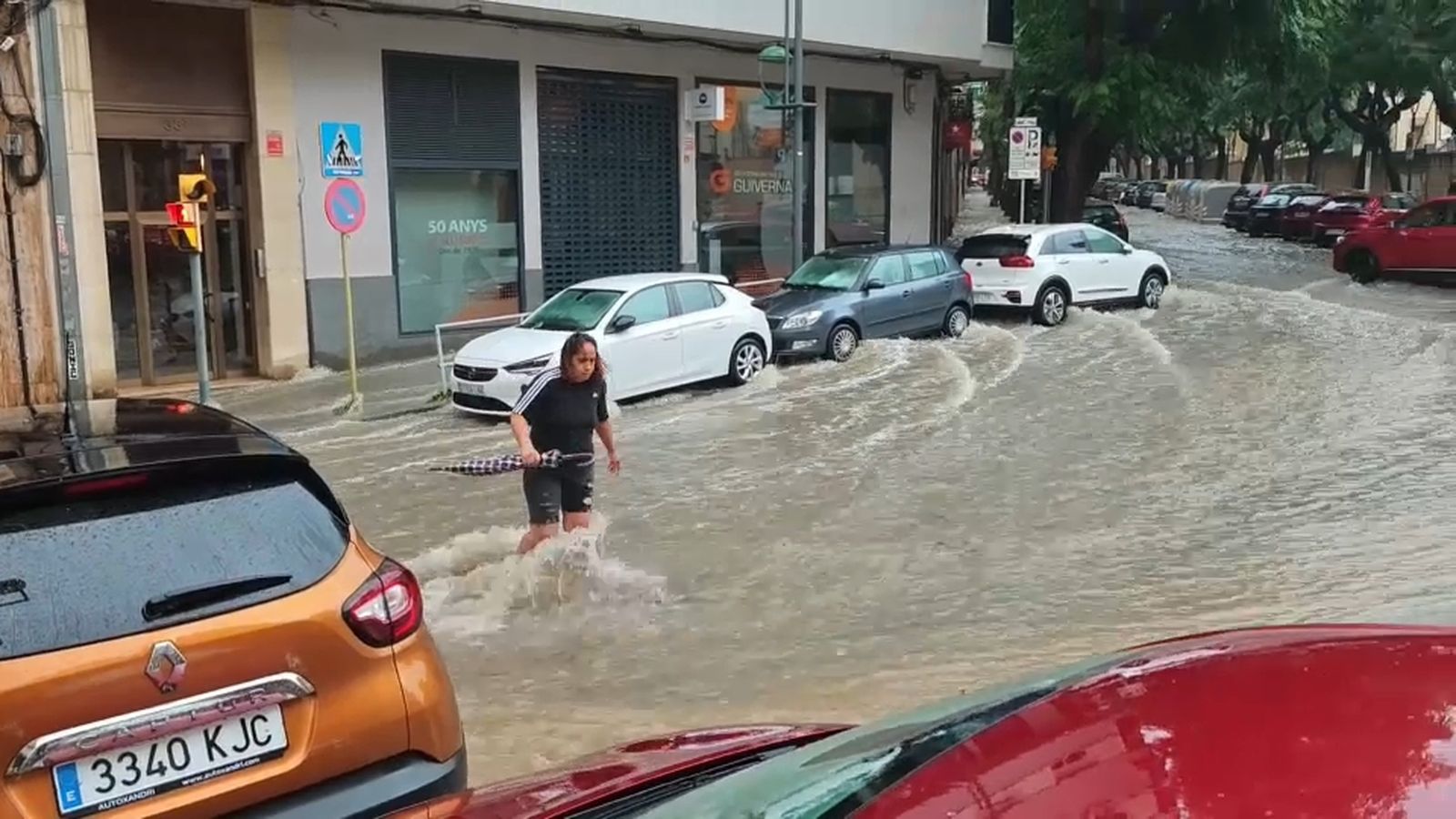 Una dona intenta creuar un dels carrers negats a la ciutat de Tarragona