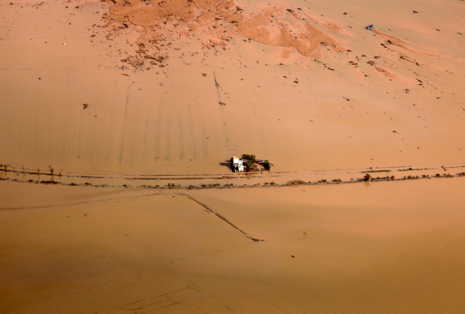 Una casa enmig d'arrossars en l'Albufera es queda aillada per l'aigua després de la dana