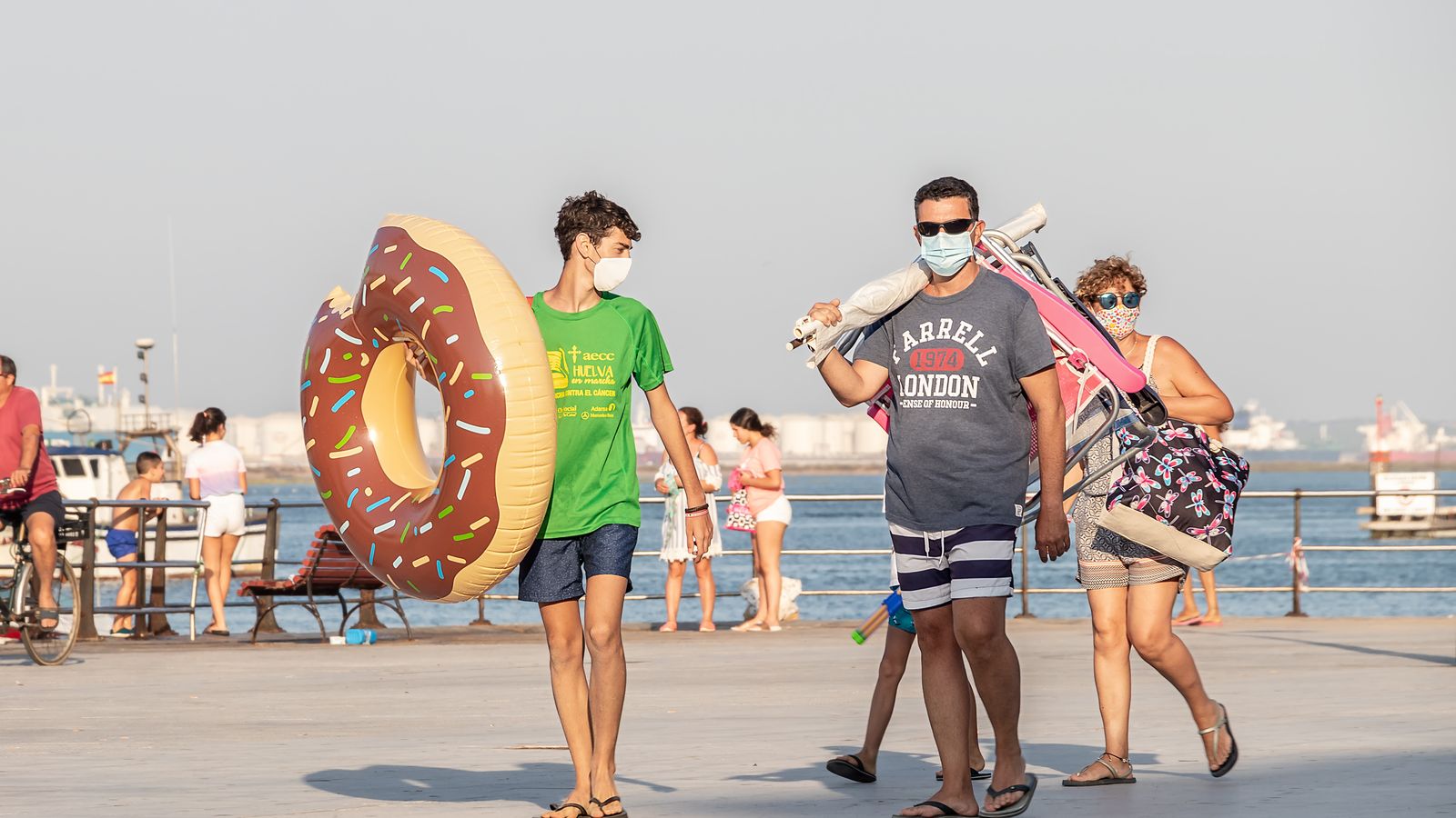 Família passejant pel passeig marítim amb la mascareta posada