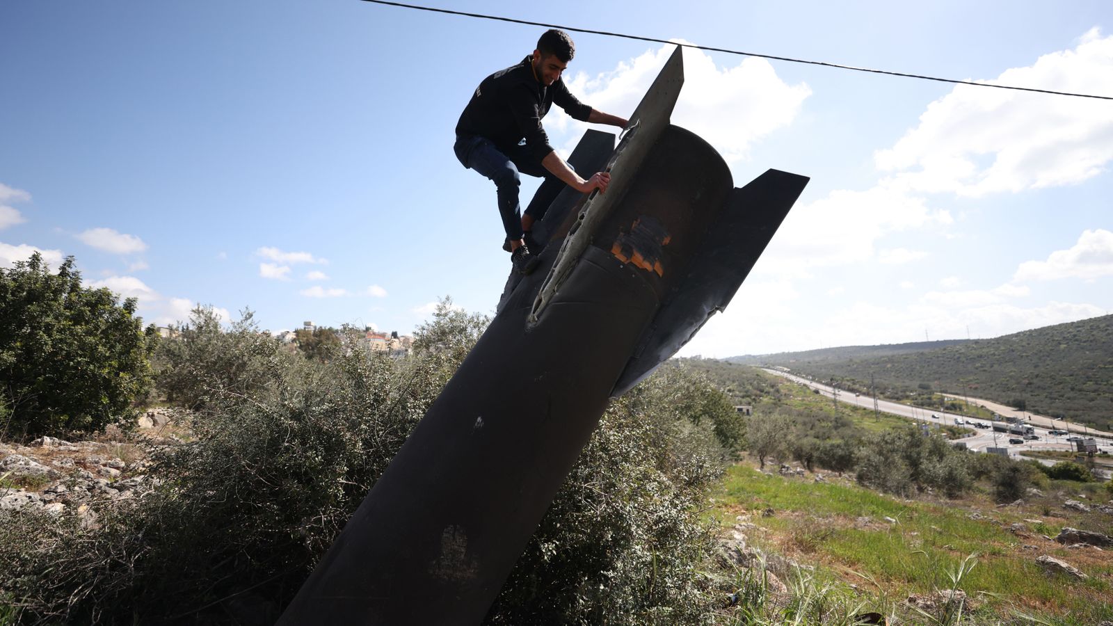 Un home escala les restes d’un míssil a Haris (Cisjordània), el 24 de març de 2026, després d’atacs des de l’Iran