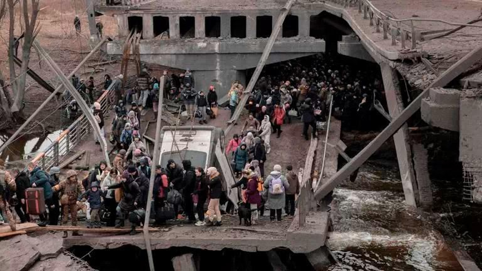 Ciutadans ucraïnesos creuen un pont destruït mentre intenten fugir de la ciutat d'Irpin, a pocs quilòmetres de Kíiv