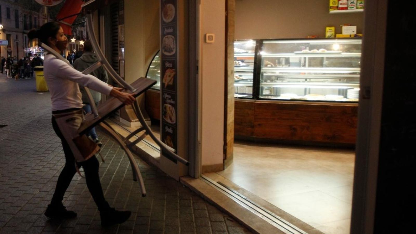 Una treballadora retira cadires d'un establiment en una imatge d'arxiu