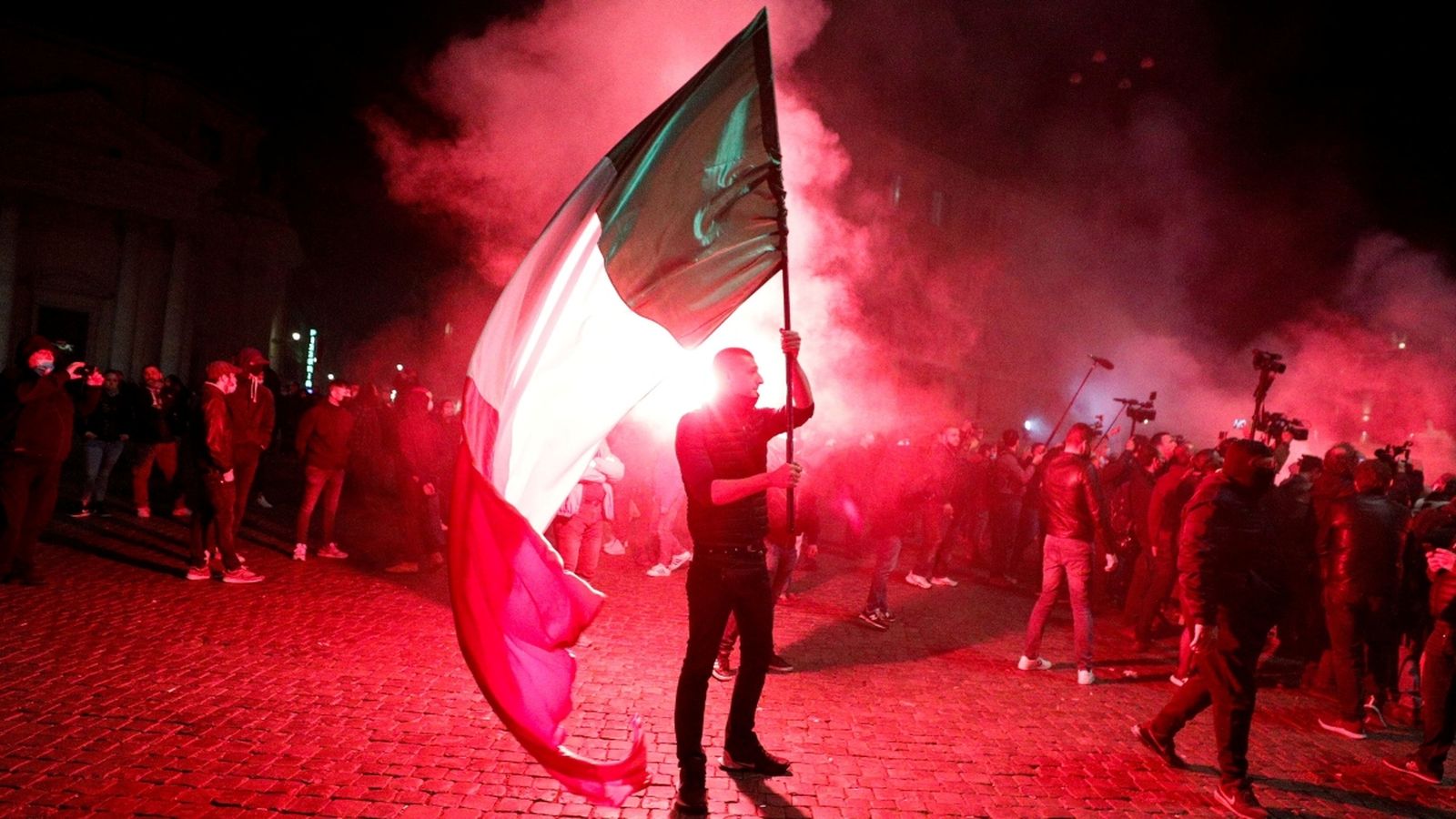Un manifestant sosté una bandera italiana durant una protesta per les restriccions
