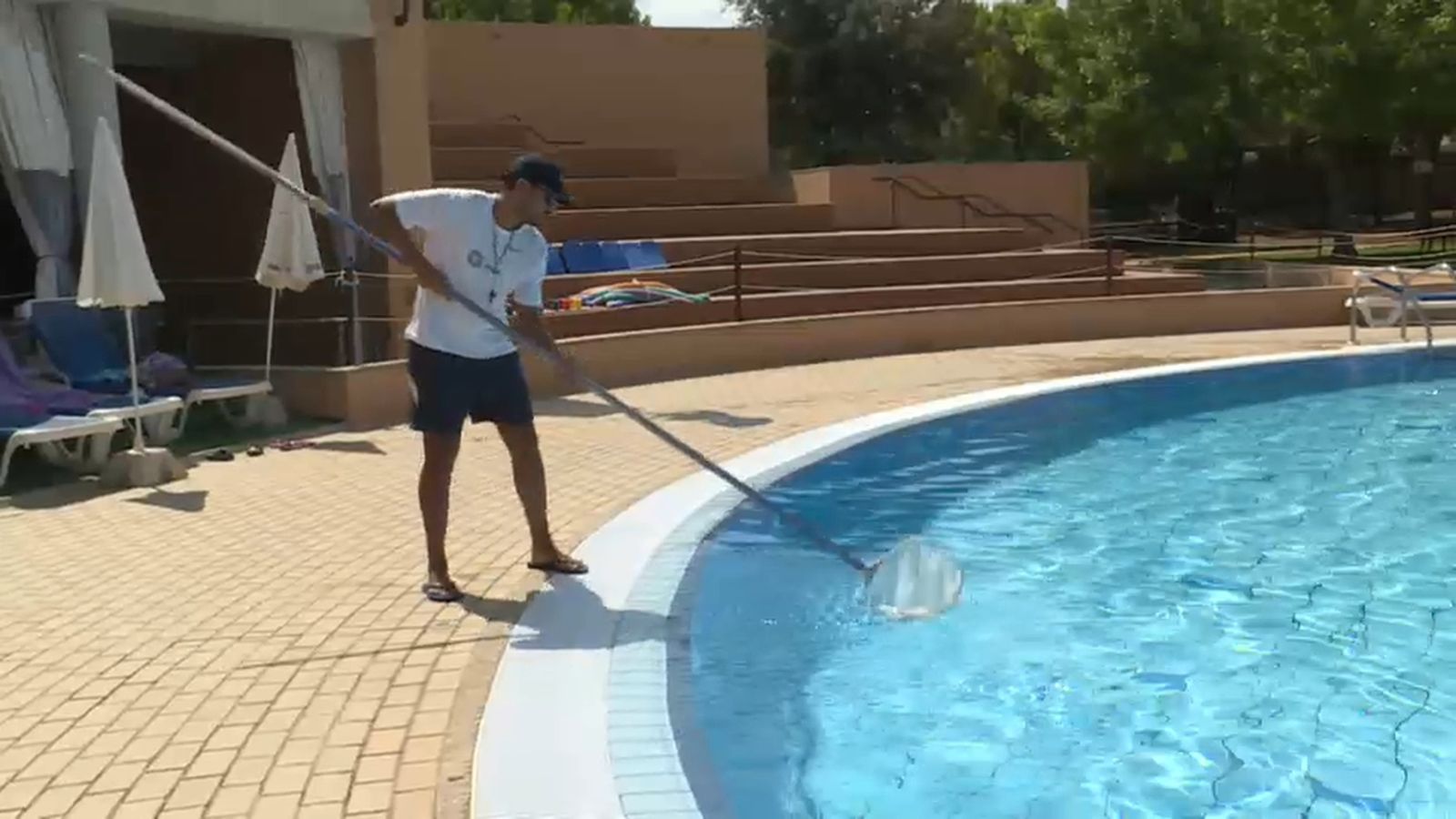 Un treballador neteja una piscina