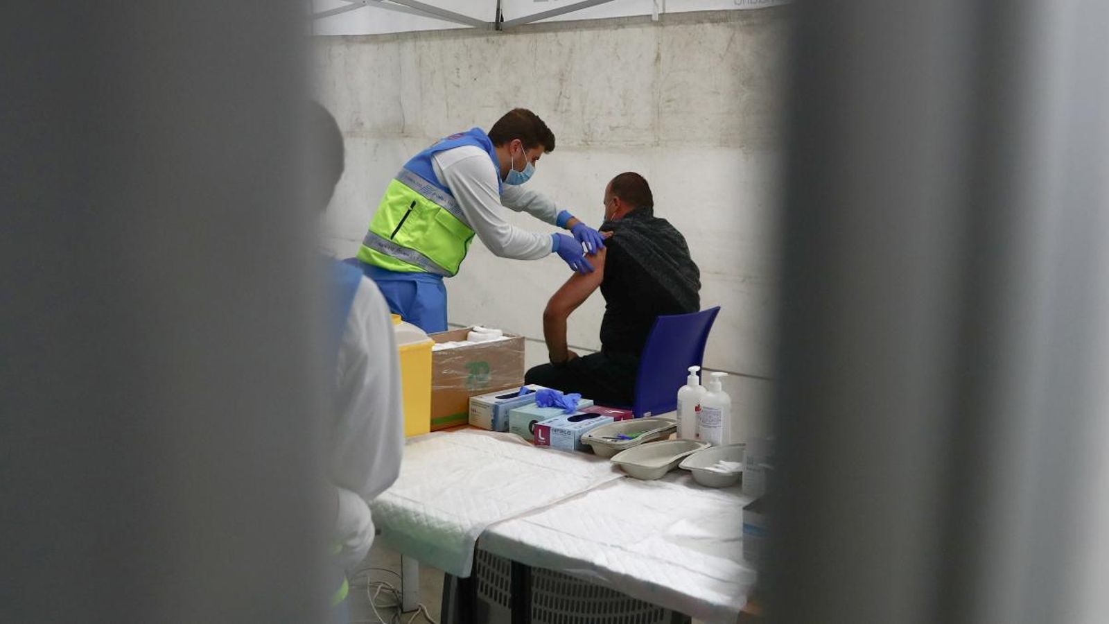 Un sanitari vacuna a un pacient en un centre en un envelat