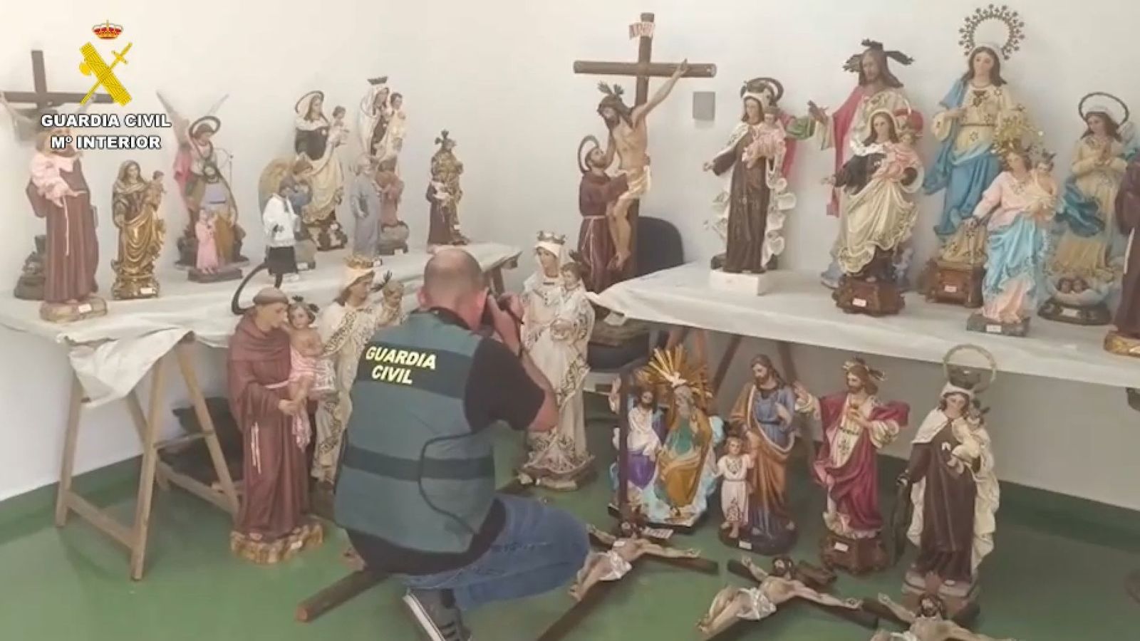 Un agent de la Guàrdia Civil fotografia una de les imatges sostretes dels cementeris asaltats