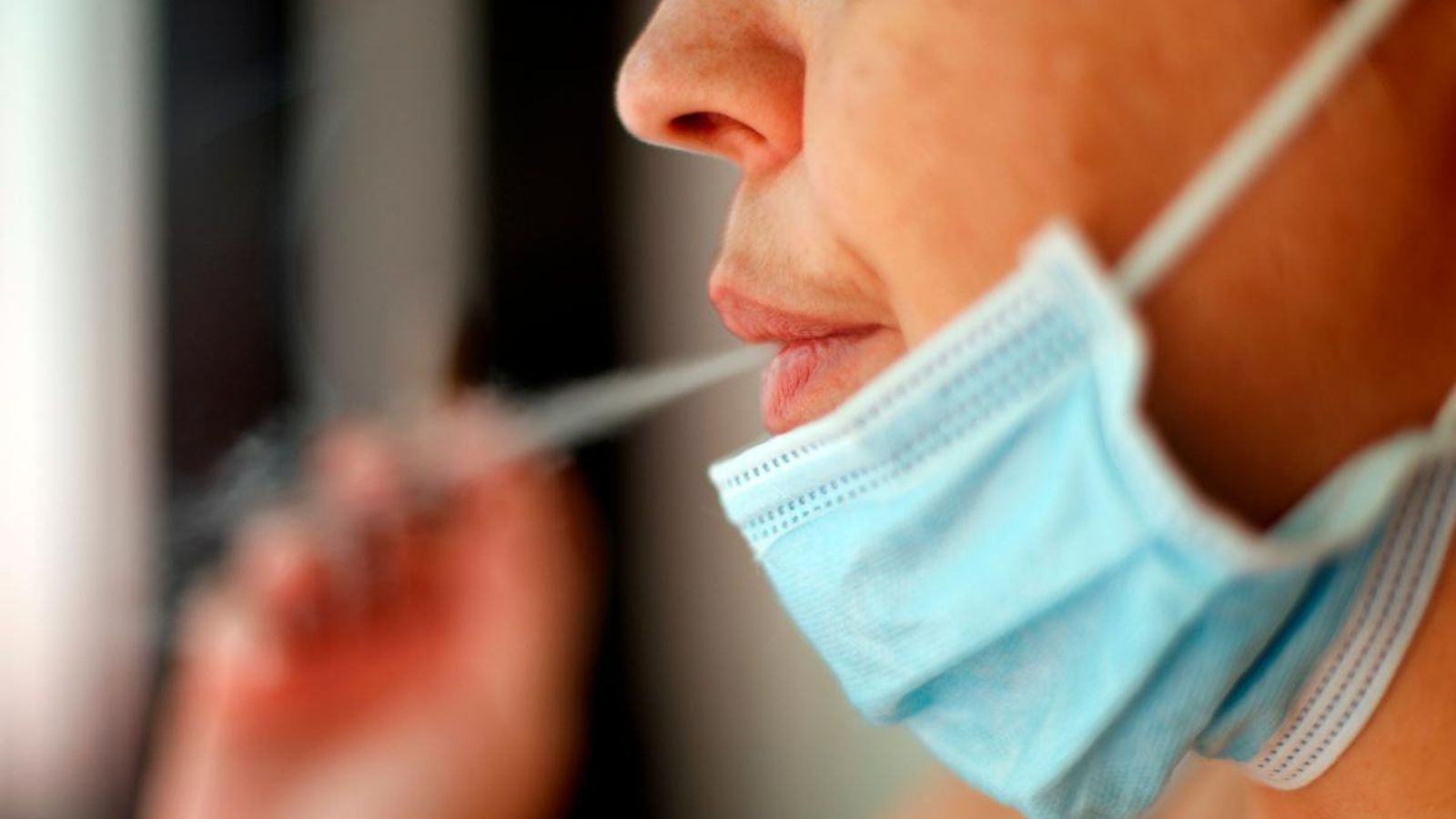 Una dona fuma amb la mascareta baixada