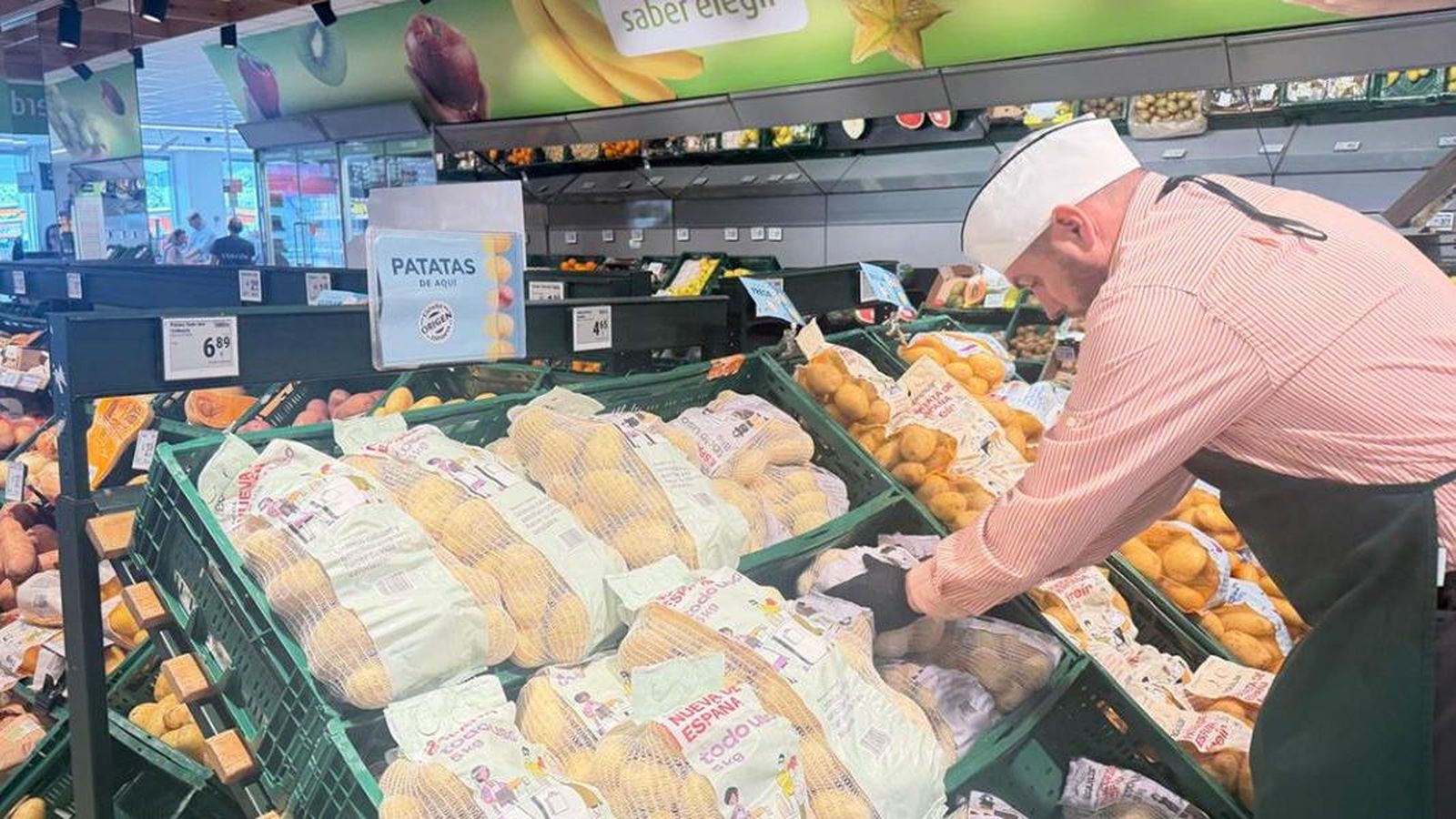 Un treballador de la secció de fruites i verdures de Consum ordena el gènere en un dels establiments de la cadena
