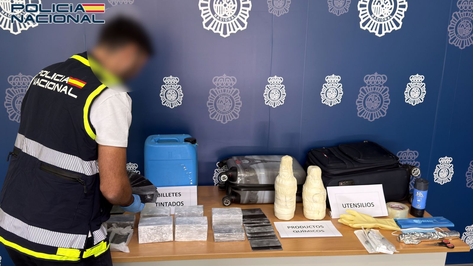 Un agent de la Policia Nacional revisa el material decomisat
