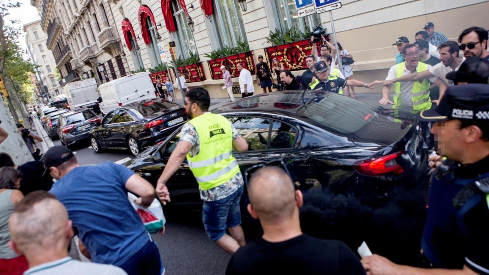 Taxistes increpen un cotxe davant de l'hotel Palace durant la manifestació pels carrers de Barcelona