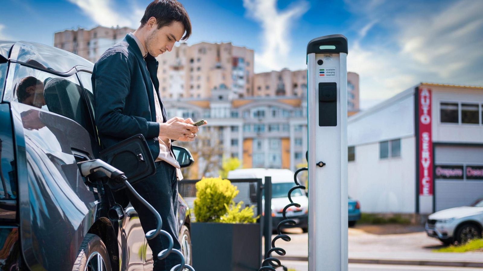 Un jove carrega el seu cotxe eléctric