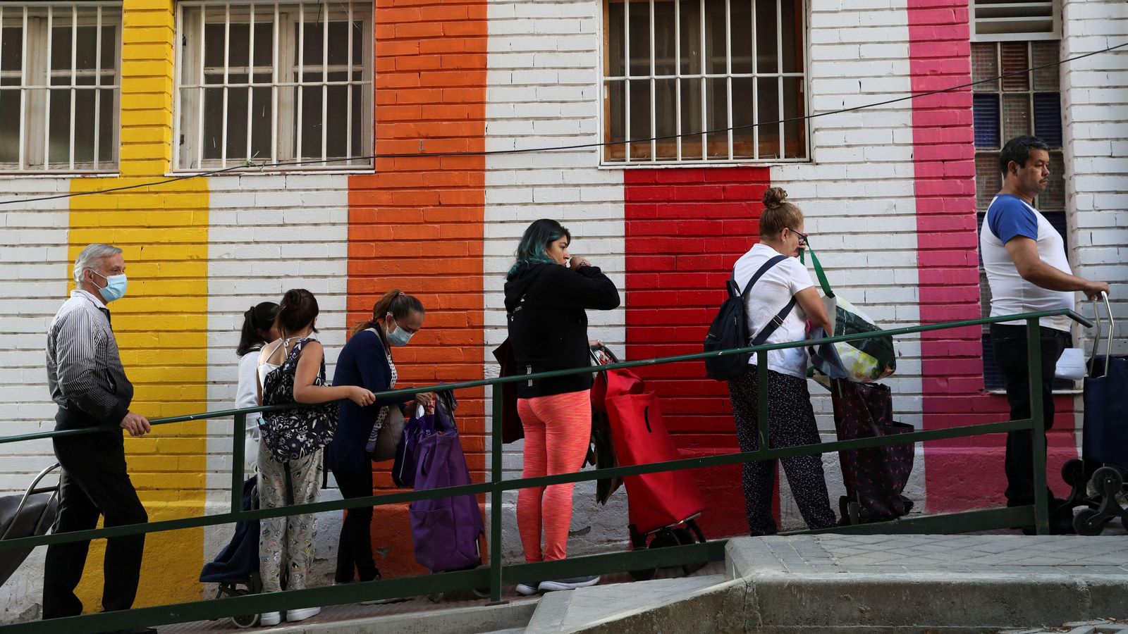 Un grup de persones fa cua per a rebre menjar en un menjador social