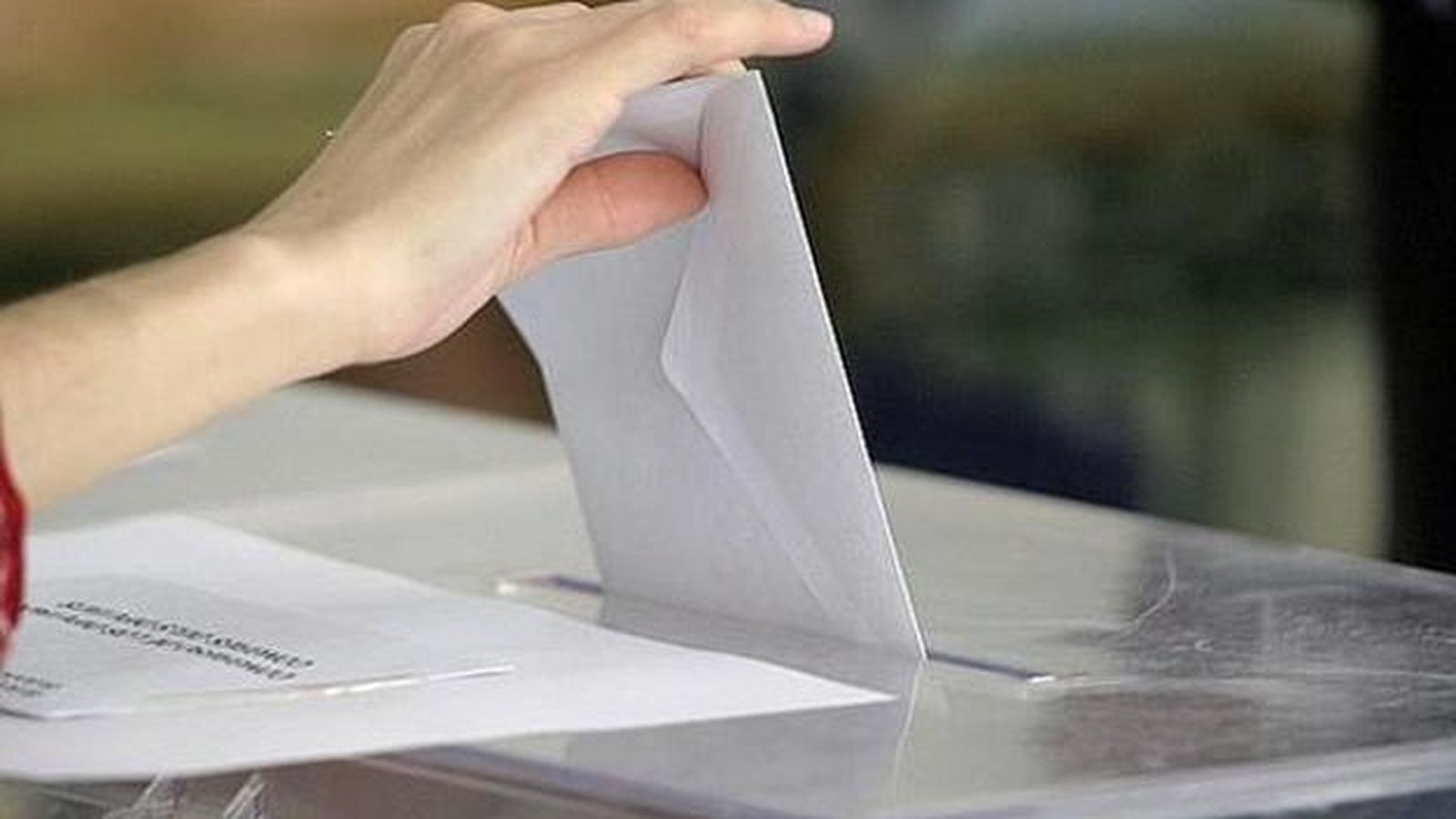 Un elector deposita el seu vot en una urna.