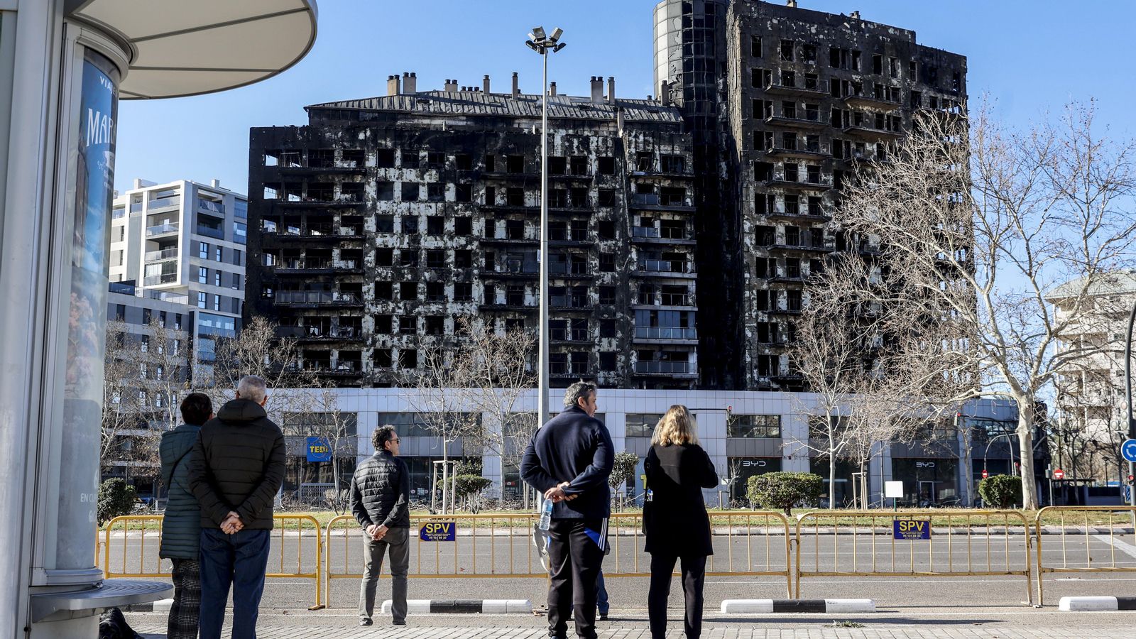 Algunes persones observen els edificis incendiats Algunes persones observen els edificis incendiats