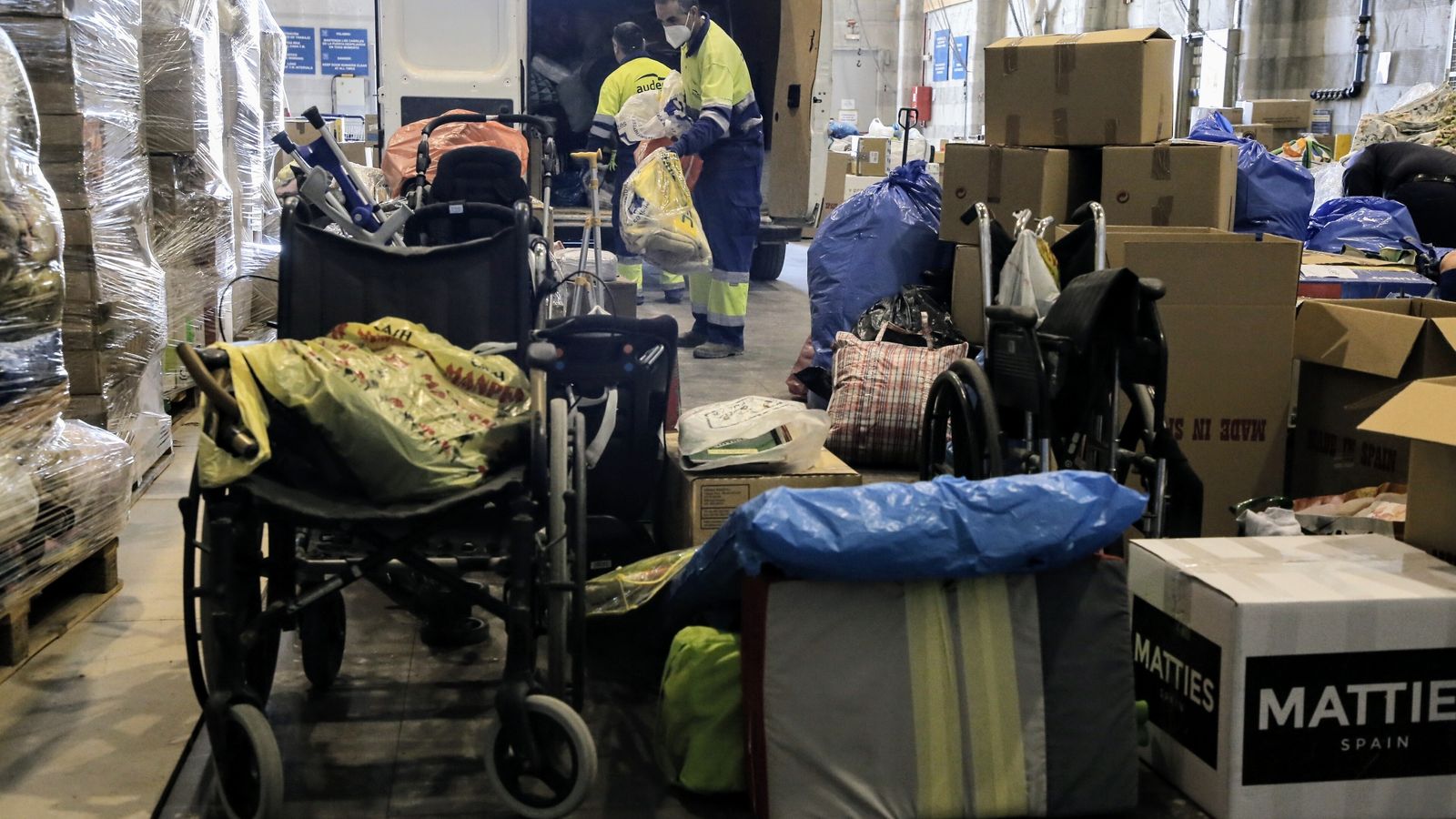 Caixes amb roba i aliments i una cadira de rodes que estan emmagatzemades a la Ciutat de la Llum d'Alacant