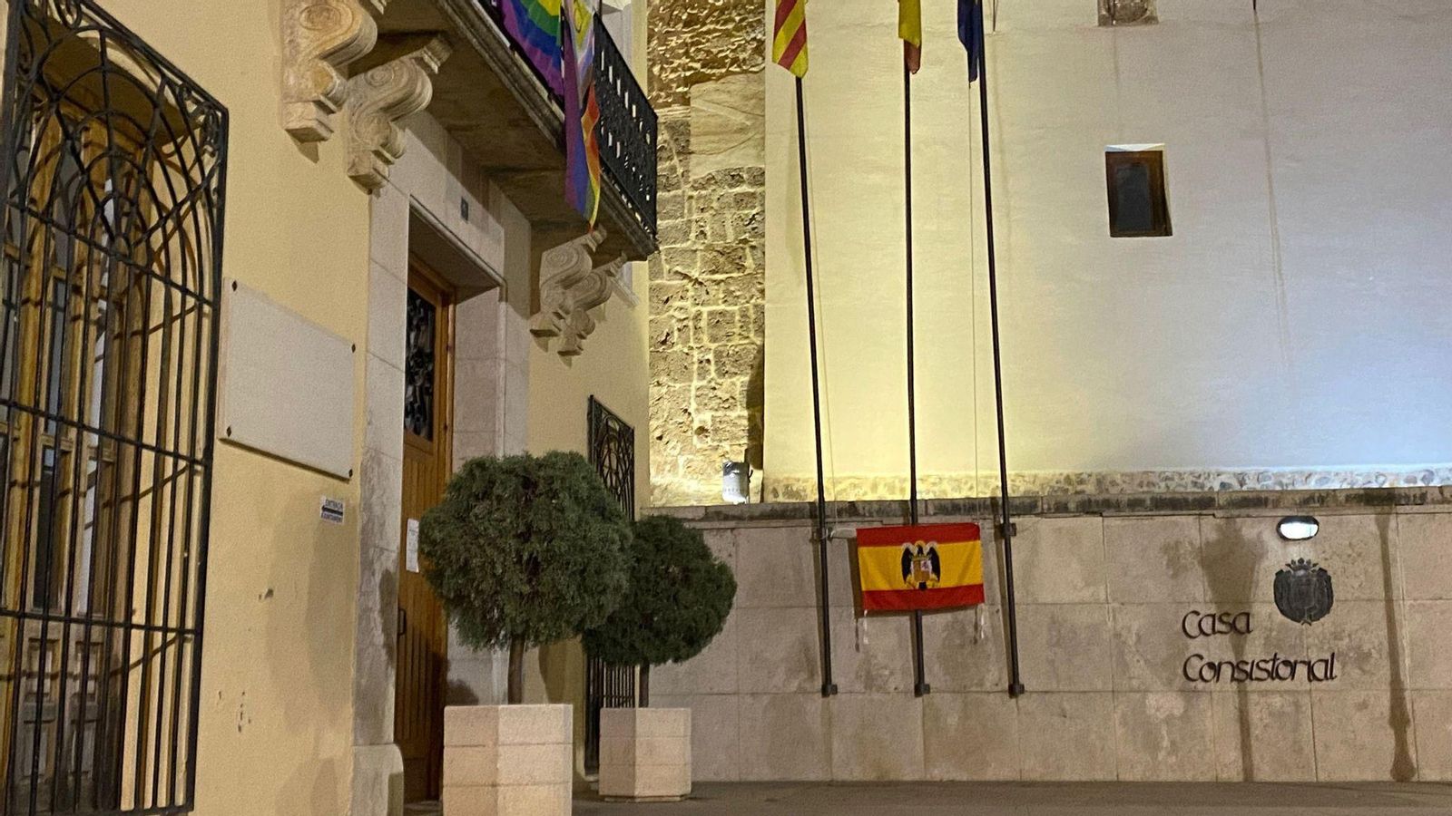 Un home penja una bandera preconstitucional a l'entrada de l'Ajuntament d'Albaida