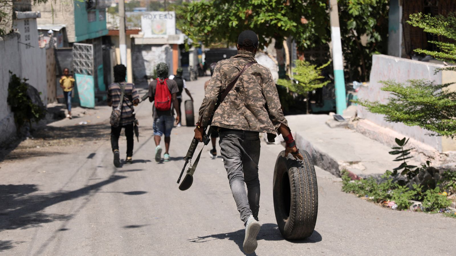 Un mercenari arrossega un pneumàtic mentre camina per Port-au-Prince, la capital d'Haití