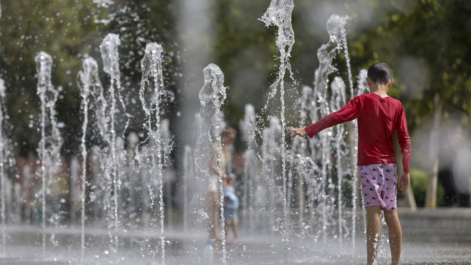 Un xiquet es refresca per a combatre les altes temperatures este dimecres a València
