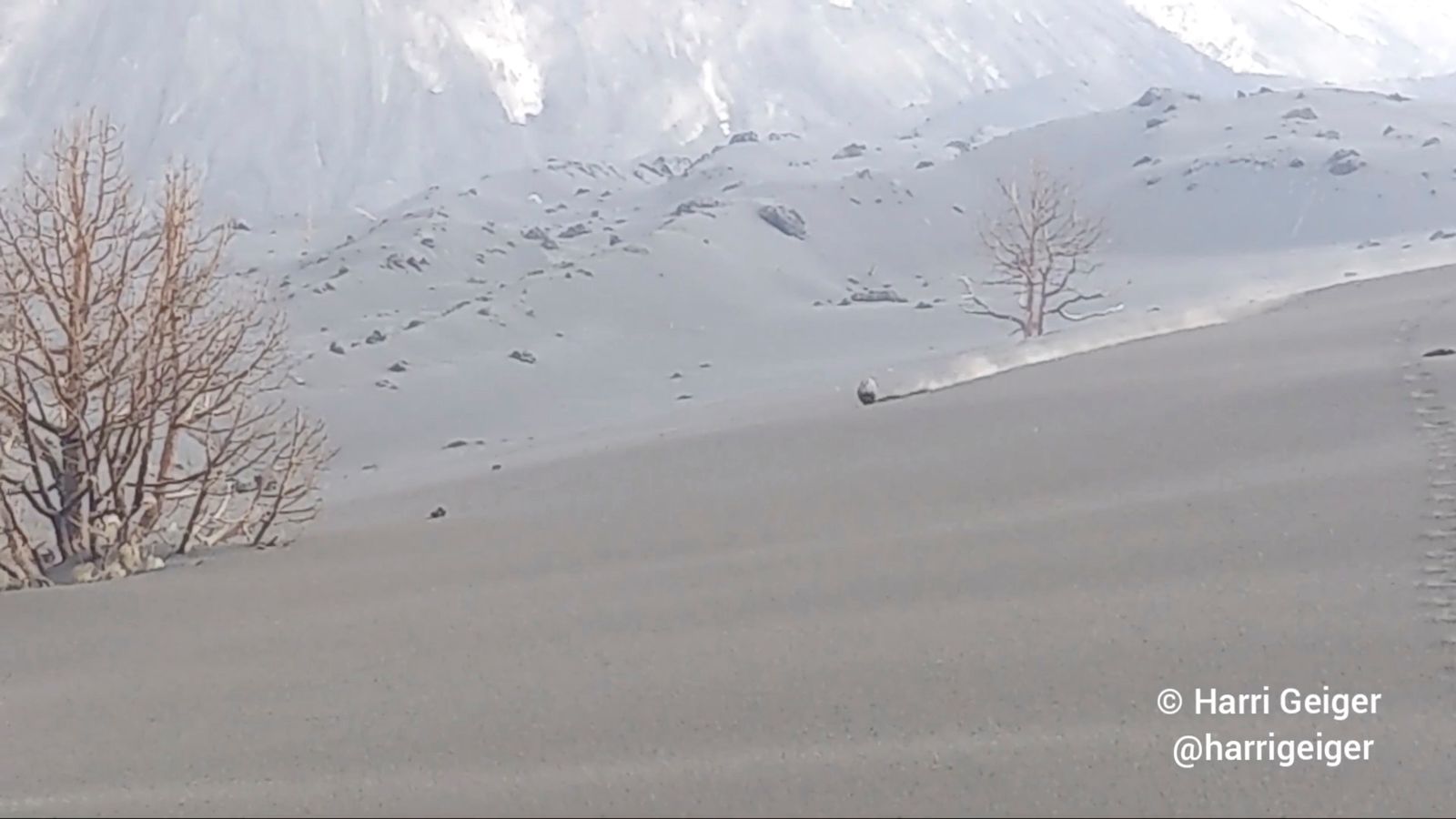 Una pedra de lava roda per un pujol ple de cendra mentre el volcà Cimera Vella continua en erupció, a l'illa canària de La Palma