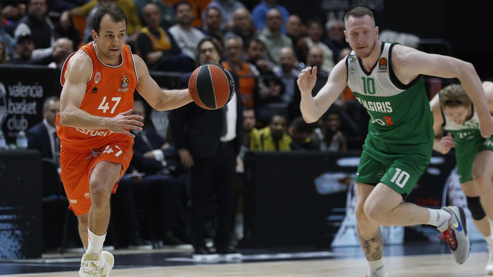 Kevin Pangos condueix la pilota davant de Roland Smith