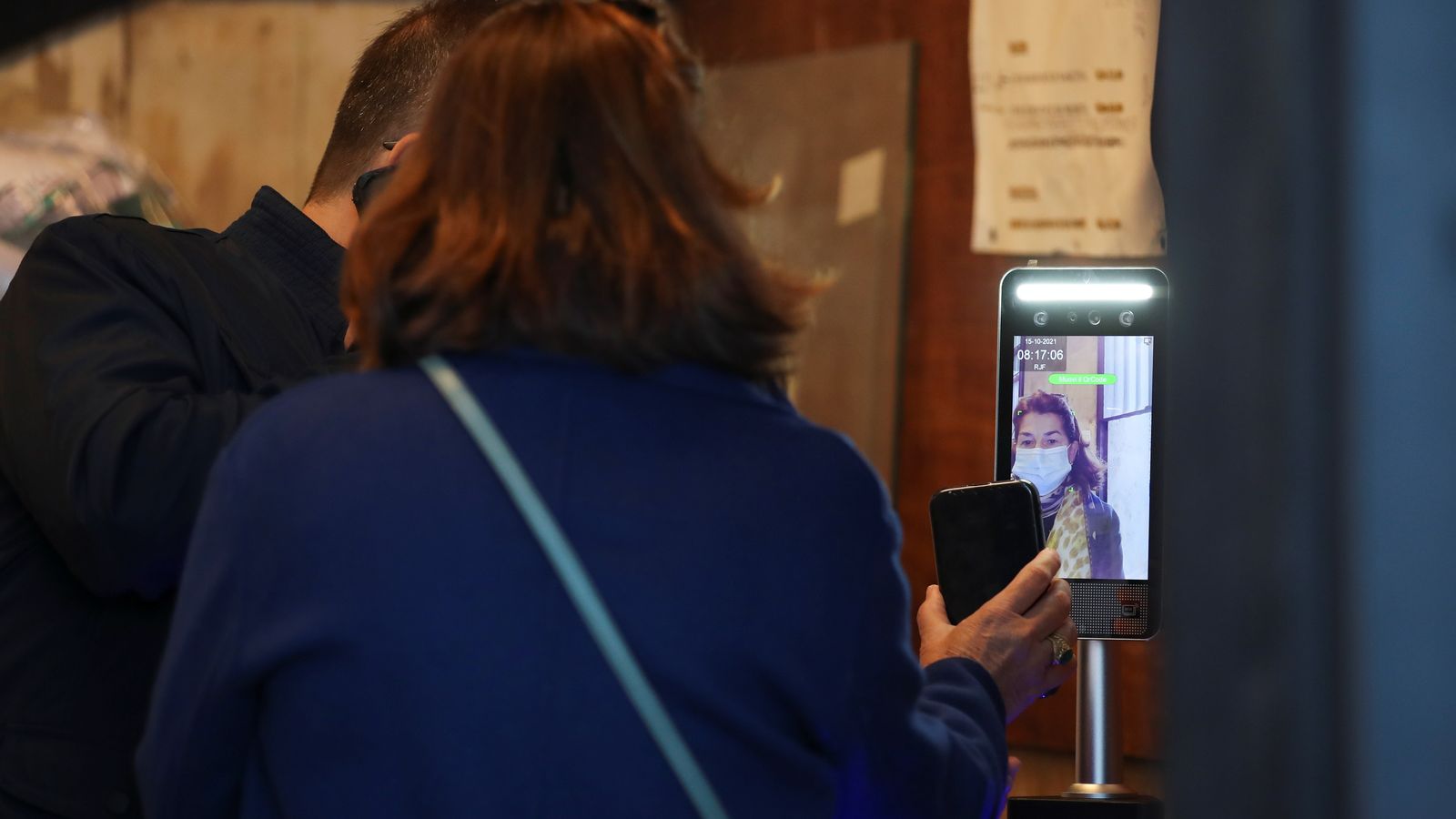 Una treballadora mostra a Roma el seu certificat de vacunació en l'entrada al treball