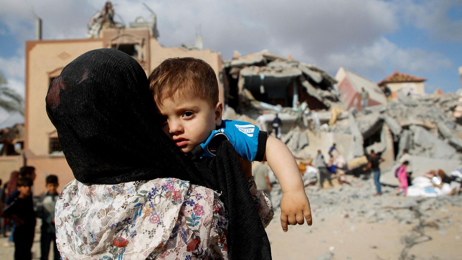 Una dona amb un xiquet palestí contempla els efectes d'un atac israelià sobre Rafah Una dona amb un xiquet palestí contempla els efectes d'un atac israelià sobre Rafah