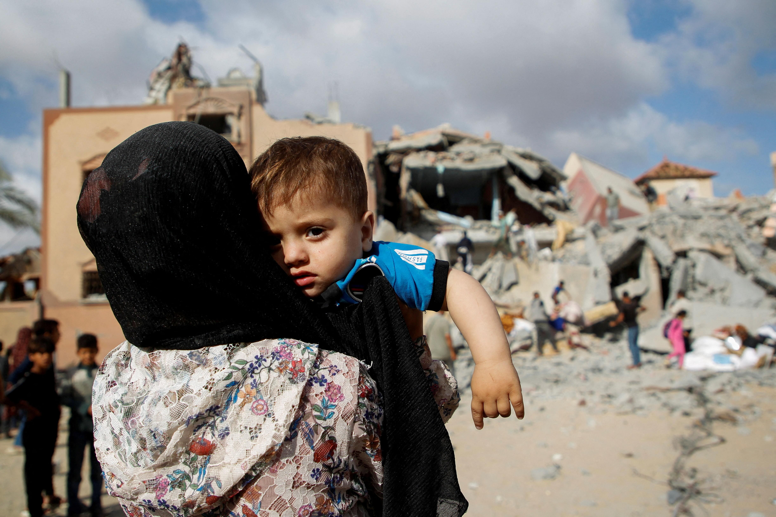 Una dona amb un xiquet palestí contempla els efectes d'un atac israelià sobre Rafah Una dona amb un xiquet palestí contempla els efectes d'un atac israelià sobre Rafah