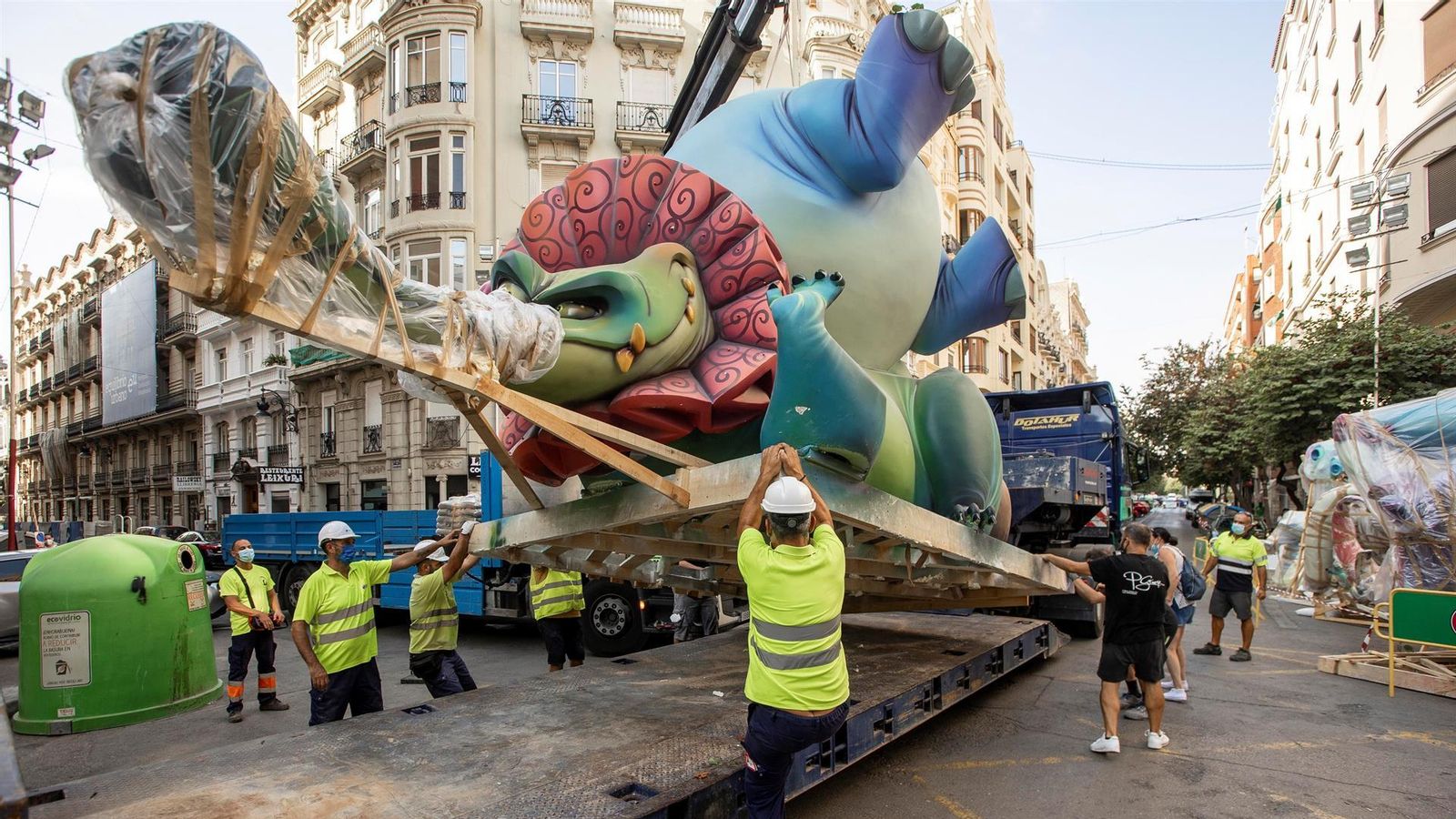 Operaris descarreguen un dels ninots que hi havia emmagatzemats a Fira València per a instal·lar-lo en el carrer