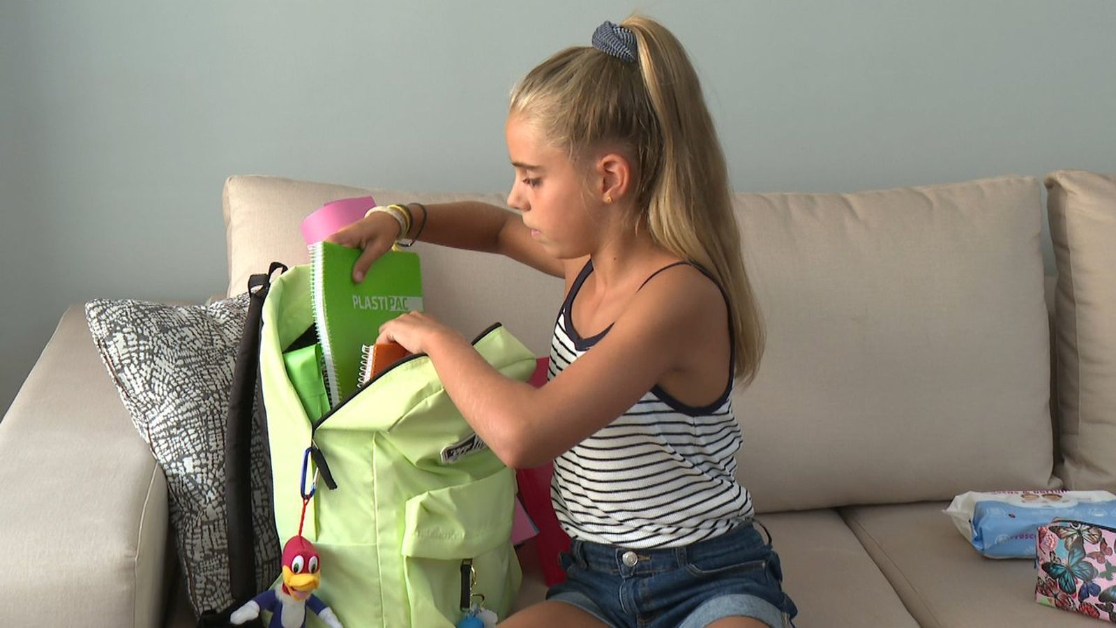 Una xiqueta prepara el material per a la tornada a l'escola