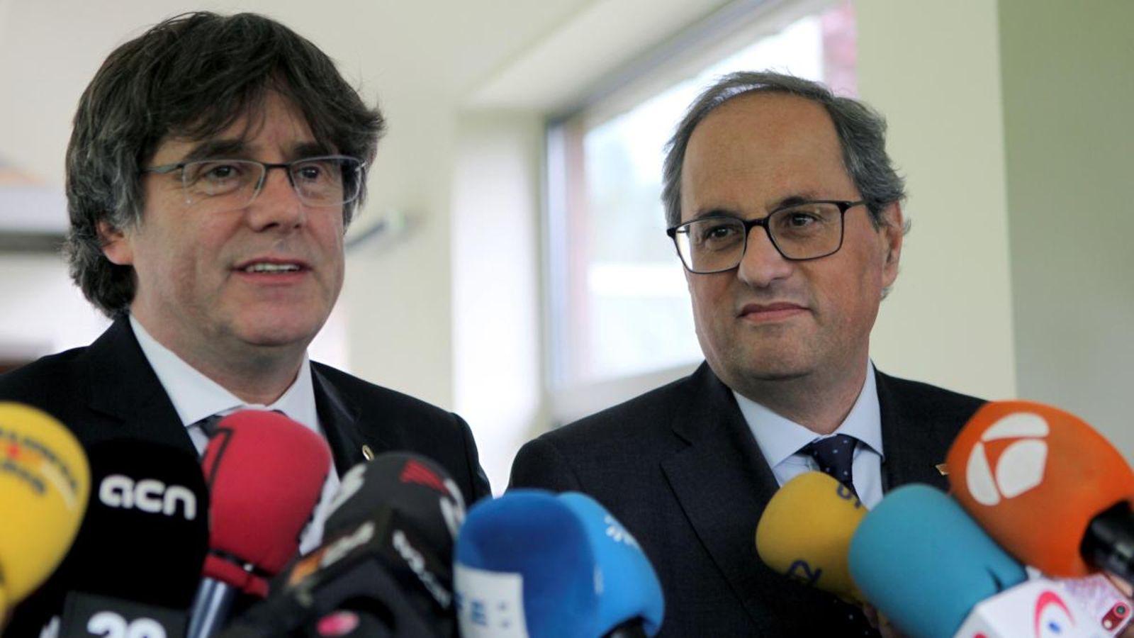 El president de la Generalitat, Quim Torra (dreta) i l'expresident català Carles Puigdemont (esquerra) compareixen davant els mitjans