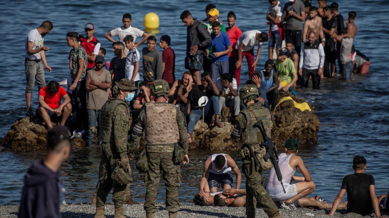 Soldats de l'Exèrcit de Terra observen com un grup d'immigrants aconsegueixen arribar a la platja fronterera del Tarajal de Ceuta
