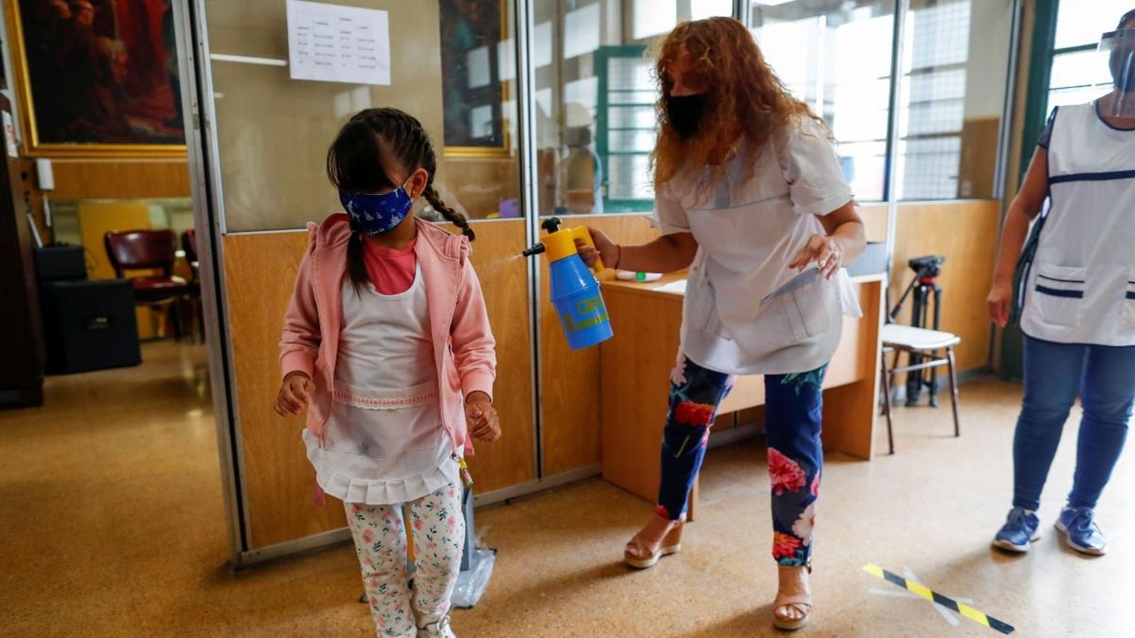 Una mestra desinfecta una alumna en una escola argentina