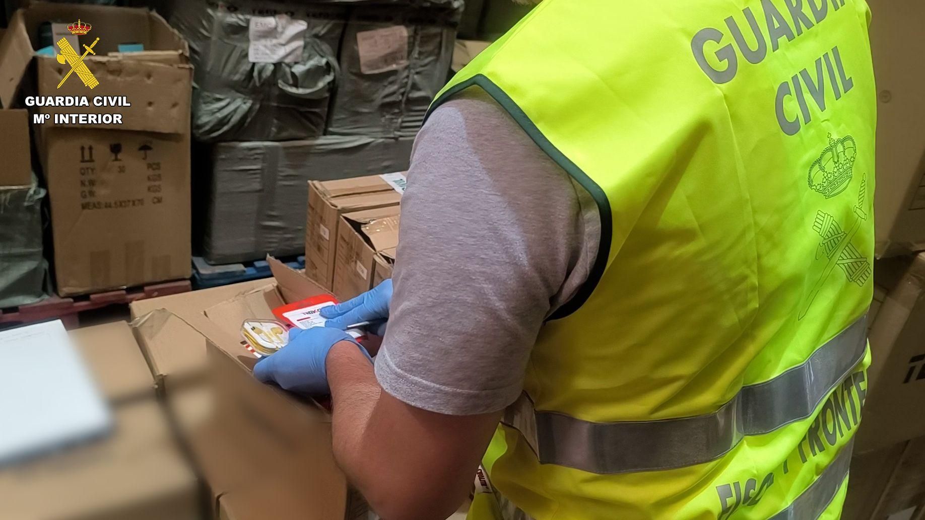 Un agent de la Guàrdia Civil inspecciona productes falsificats que s'emmagatzemaven a les naus Un agent de la Guàrdia Civil inspecciona alguns productes falsificats que s'emmagatzemaven en les naus