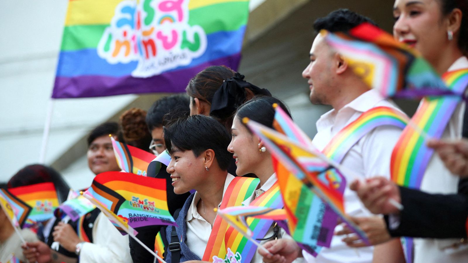 Els membres de la comunitat LGBTQ+ porten banderes que diuen "Igualtat matrimonial, l'amor guanya" Els membres de la comunitat LGBTQ+ porten banderes que diuen "Igualtat matrimonial, l'amor guanya"