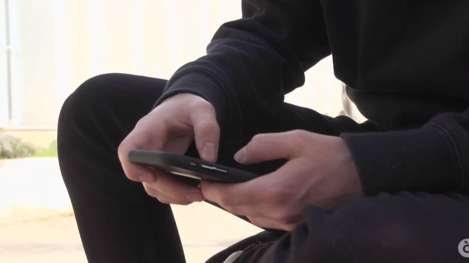 Un adolescent utilitza un mòbil