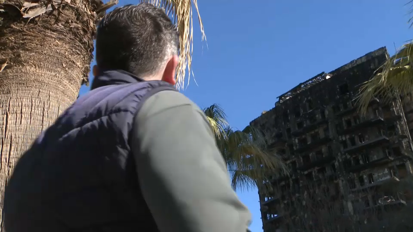 Un home mira l'edifici incendiat a Campanar