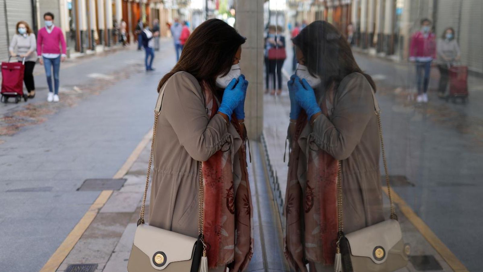 Una dona amb mascareta mira a través d'un aparador de Ronda, a Màlaga