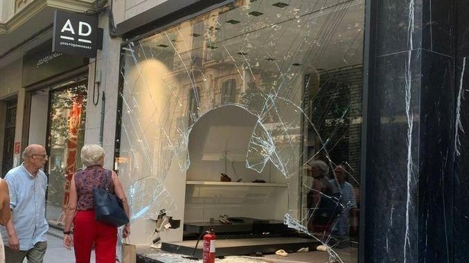 Estat en què ha quedat l'aparador de la botiga després del robatori amb l’encastament Roben bosses de mà i sabats de luxe d'una botiga de València després d'un allunatge