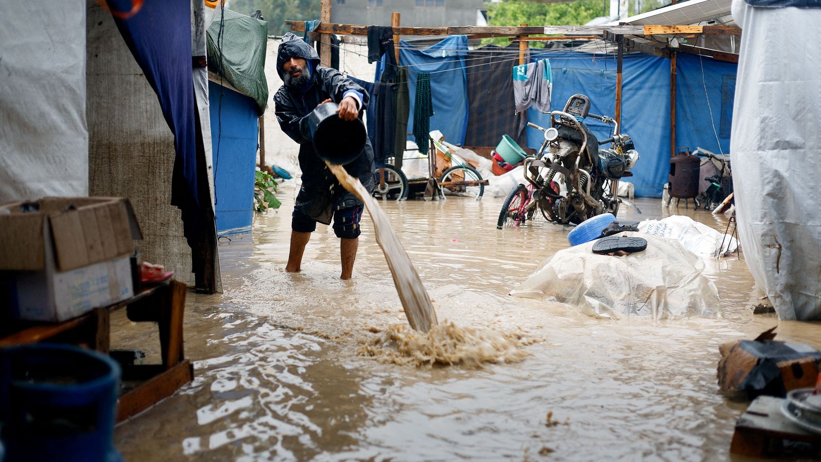 Un home tracta de llevar aigua d'una tenda a un campament de Nuseirat, el la zona central de la Franja de Gaza